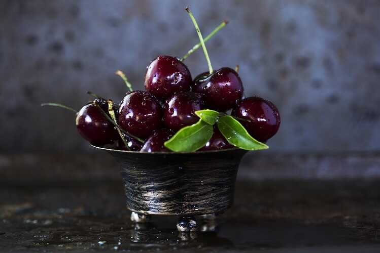 red cherries on stainless steel bowl