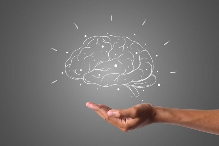 Image depicting a drawn brain floating over a hand