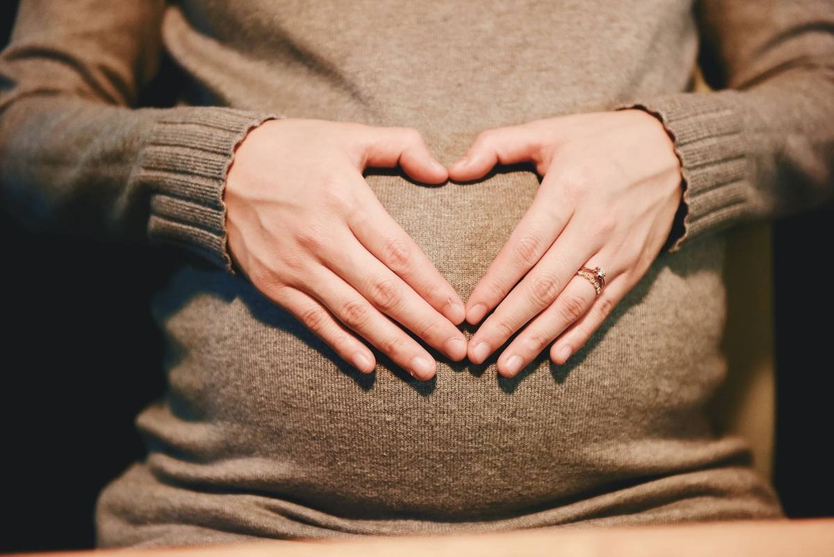 Preganant woman shaping a heart with her hands