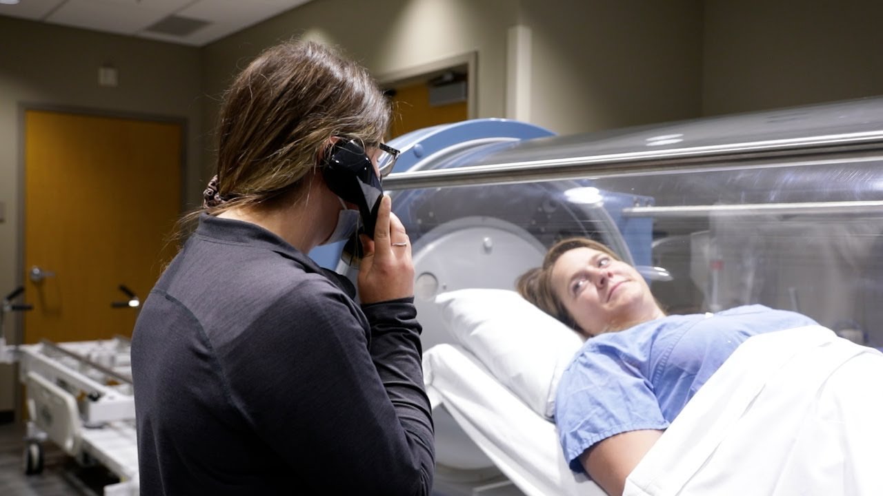 A woman in laying in a hyperbaric oxygen therapy chamber in an HBOT treatment center