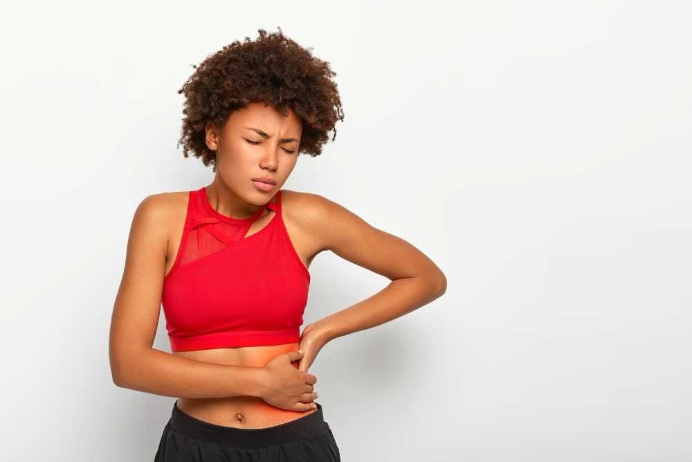 Dissatisfied woman holds aching hip has kidney inflammation.