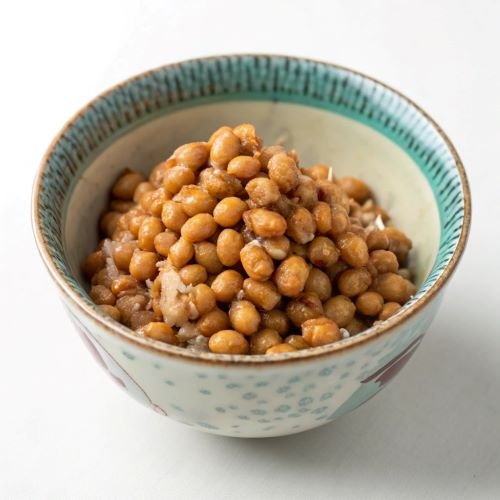 Small, light-brown soy beans (Nattokinase) in a decorative bowl.