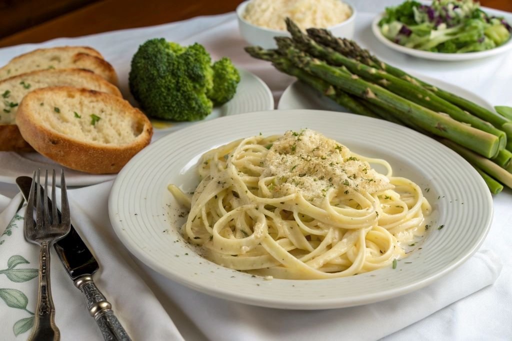 Fettucine alfredo served with asparagus, broccoli and garlic bread